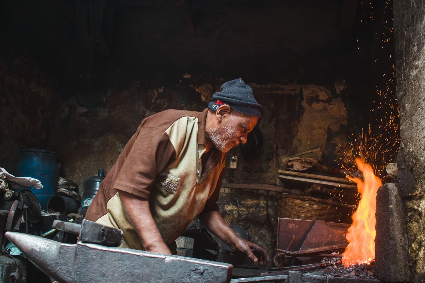 Herrero trabajando metal en la fragua del taller